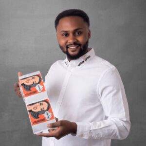 Jeremy Appiah, Sachbearbeiter im Verkaufsinnendienst Media bei WILUX PRINT, hält eine Etikettenrolle in die Kamera, professionell gekleidet in einem weissen Hemd, vor einem neutralen Hintergrund.